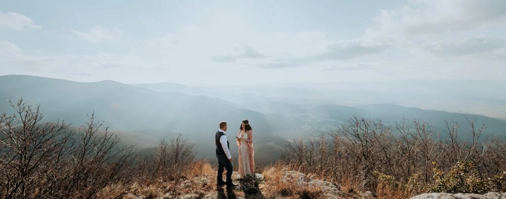 A wide shot of a couple saying their vows on a mountaintop in Virginia