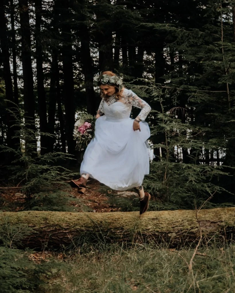 An eloping bride leaps from a log.