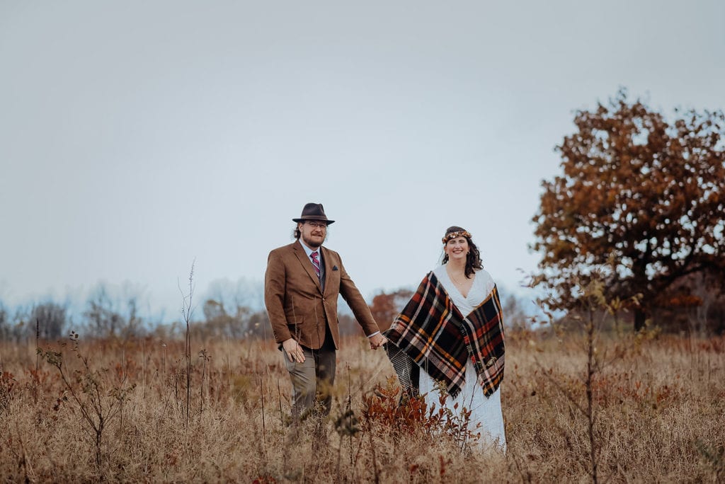 A couple having and elopement wedding in Shenandoah National Park poses in the tall grass at Big Meadows.