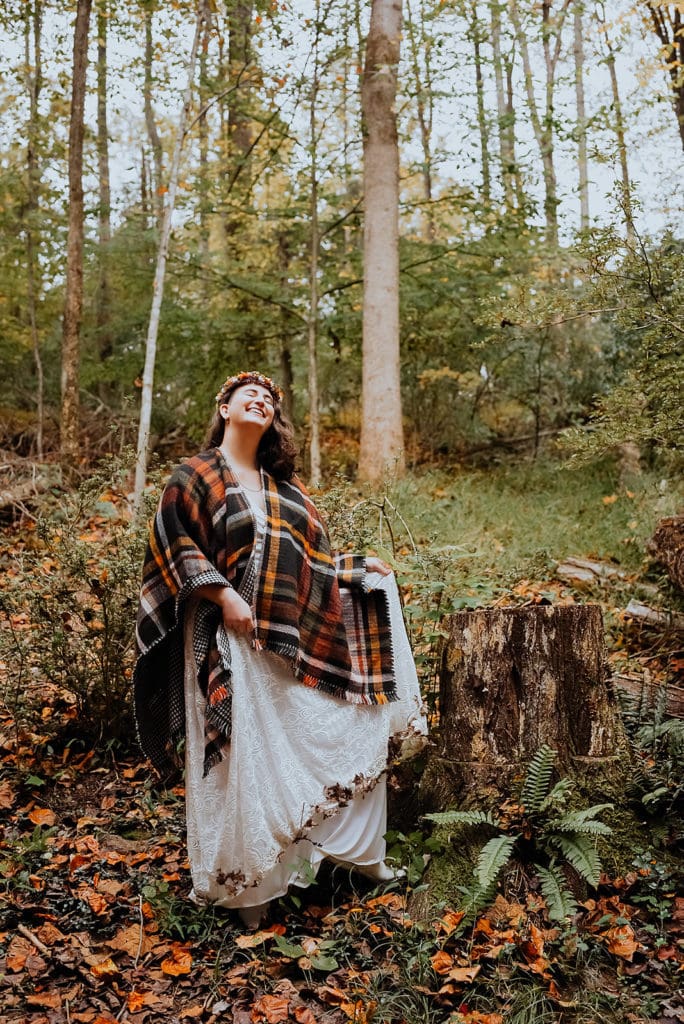 A bride who eloped in Shenandoah National Park shows off her dirty dress and her hem covered in leaves.